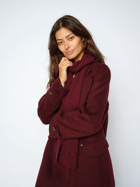 Model wears the Mos Mosh Tova wool Scarf in a dark burgundy shade