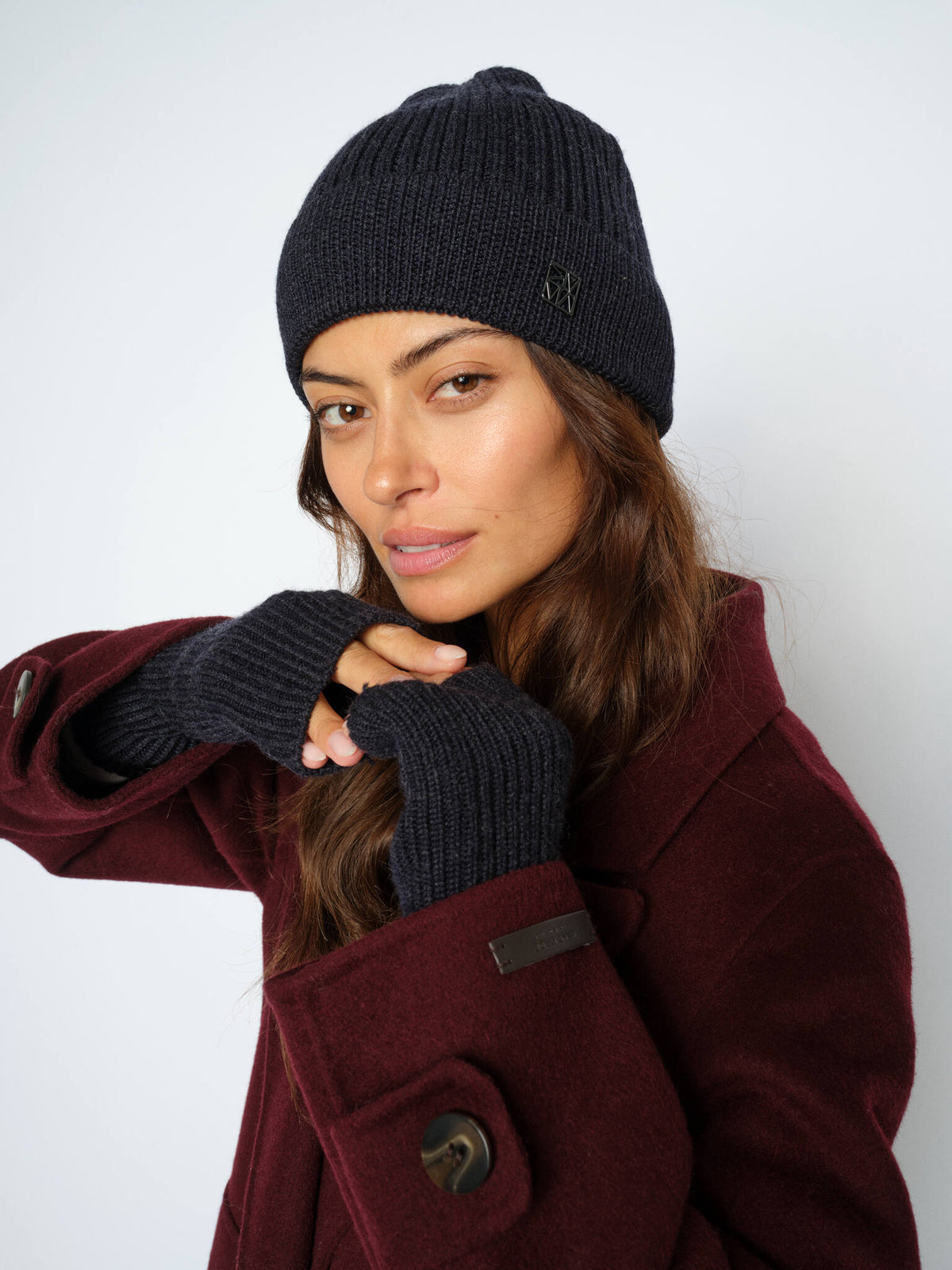 Model wears Mos Mosh dark navy Tova hat and mittens from The Shoe Gallery