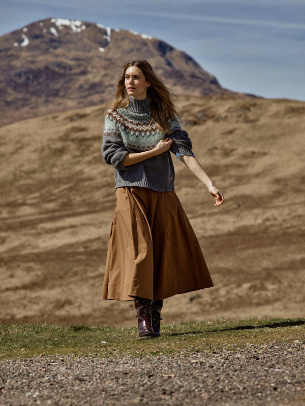 Model wears the Mos Mosh Daya Fjord sweater featuring a jacquard brown and frosty green fair isle patter on grey from The SHOE GALLERY teamed with a brown skirt and boots