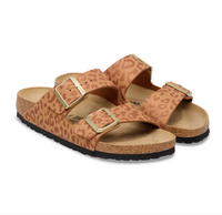 Pair of leopard print Birkenstock Arizona sandals with gold buckles on a white background