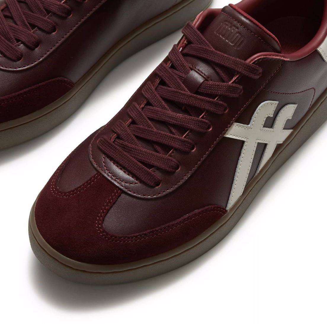 FitFlop Dash Trainer  in dark merlot leather with suede toe and cream toned fitflop branding on the side and at the heel.