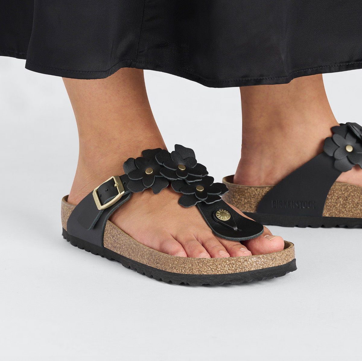 birkenstock black flower embellished Gizeh sandals with buckle closure worn by model, close-up