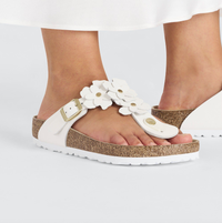 A pair of Birkenstock white leather flower embellished sandals with buckle closure