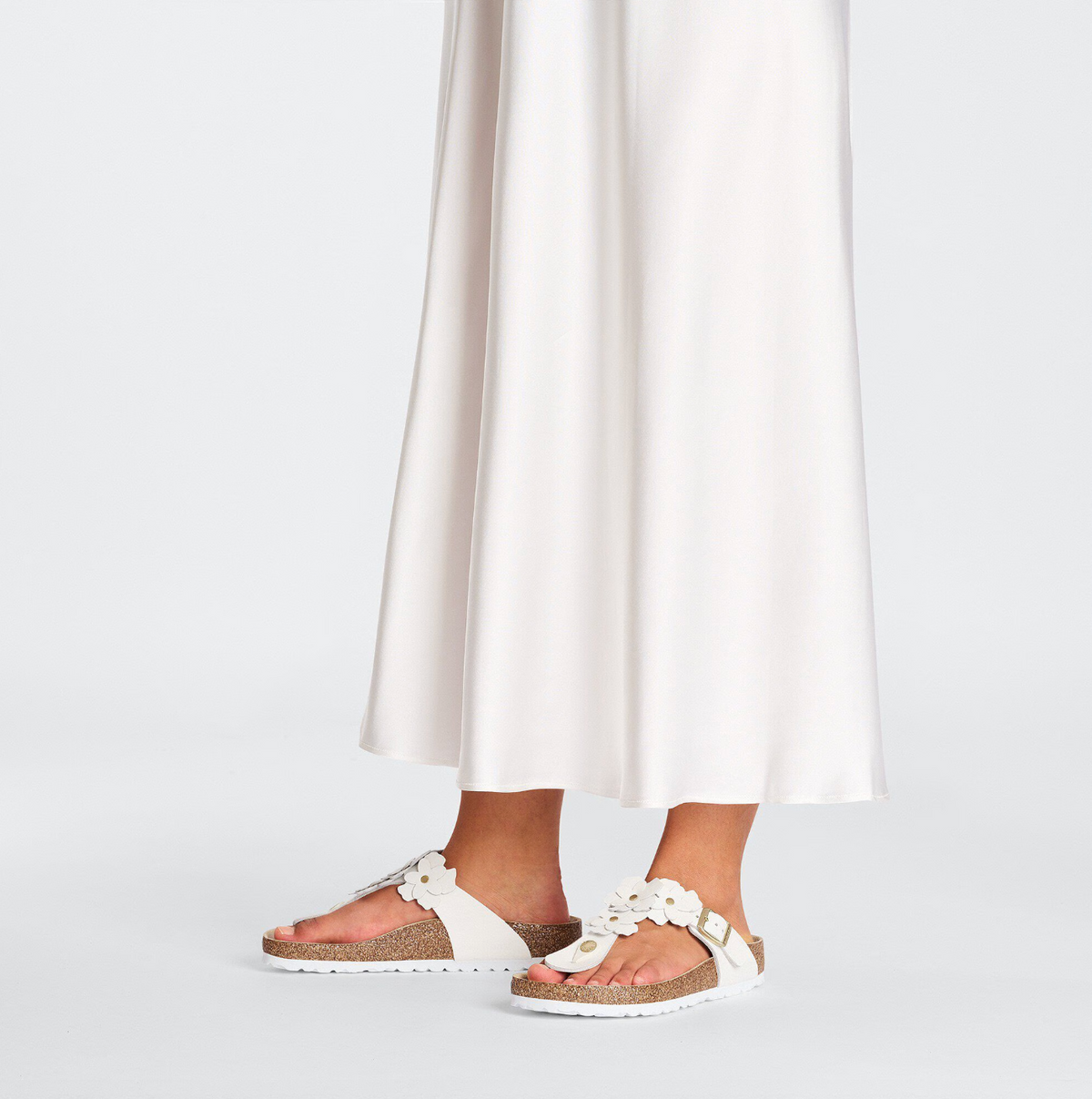 A pair of Birkenstock white leather flower embellished sandals with buckle closure