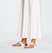 A pair of Birkenstock white leather flower embellished sandals with buckle closure