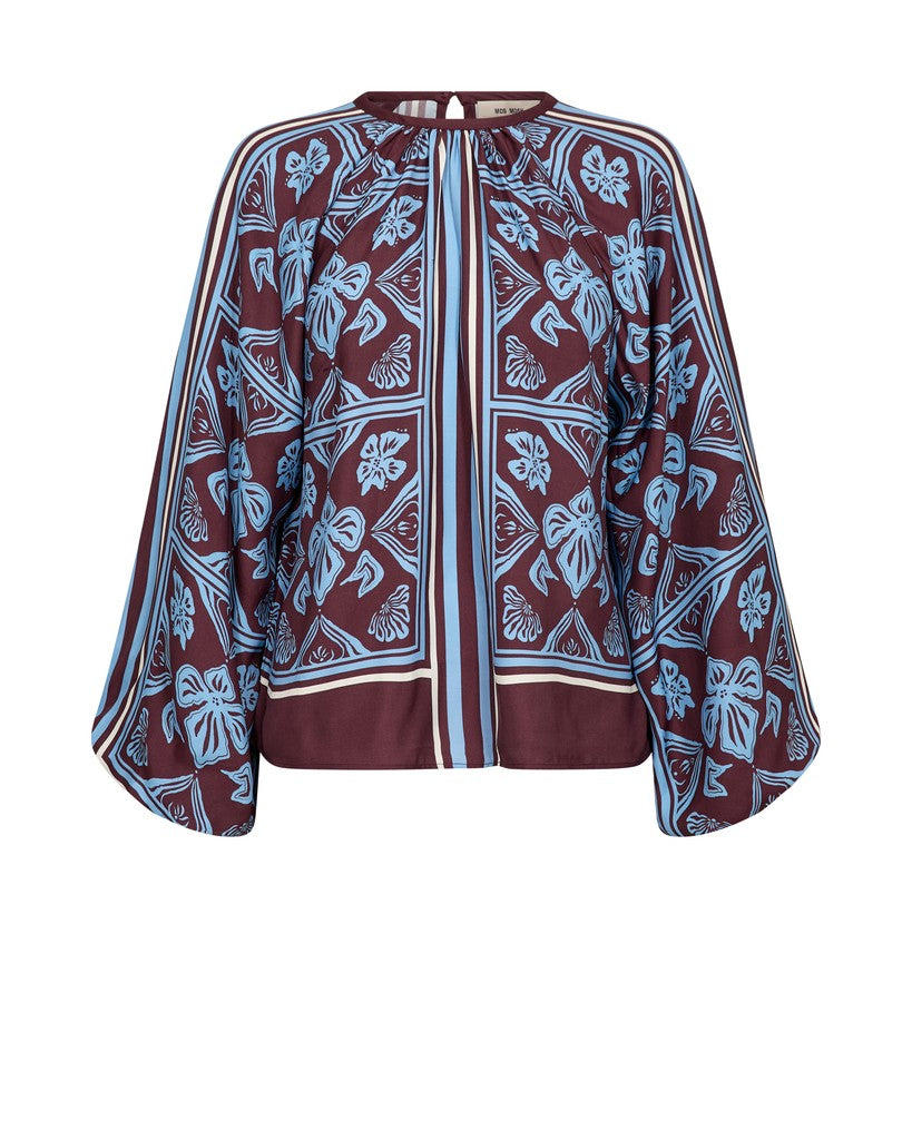 A long-sleeve Mos Mosh blouse with a maroon base and a light blue and white botanical block print pattern, featuring a split neckline 