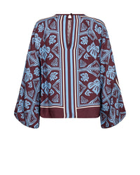 A long-sleeve Mos Mosh blouse with a maroon base and a light blue and white botanical block print pattern, featuring a split neckline 