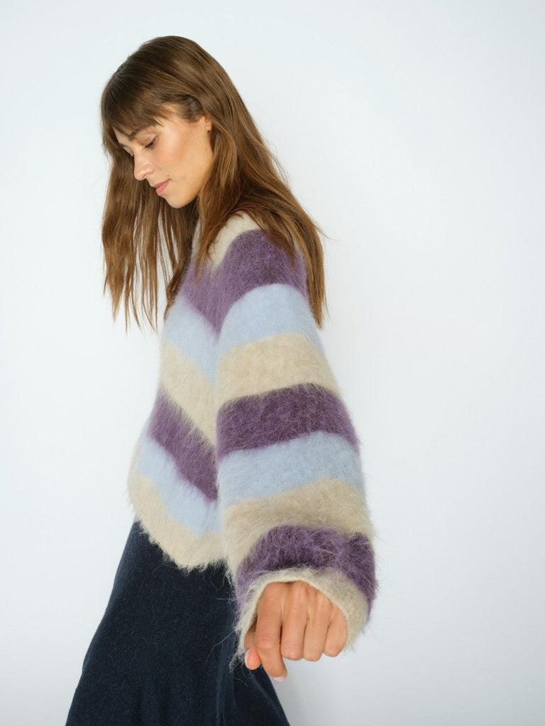 Model wears a striped Mos Mosh sweater in purple blue and beige