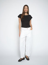 model wears white cotton denim barrel jeans