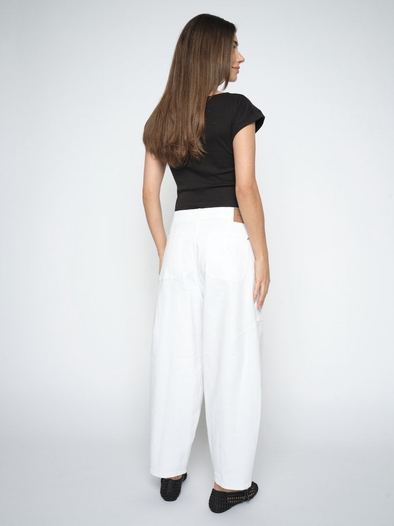 model wears white cotton denim barrel jeans