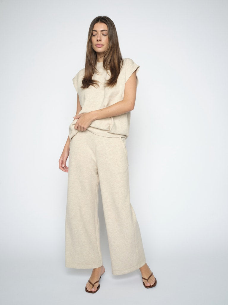 model wears a sleeveless relaxed style top teamed with cropped sweatpant