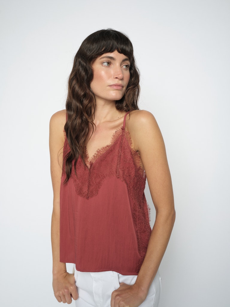 model wears a terracotta slip top dged with fine lace