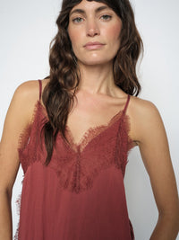 model wears a terracotta slip top dged with fine lace
