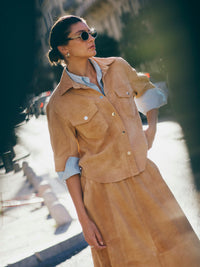 model is wearing a tan suede jacket with three quarter sleeves