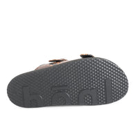 Back view of a sandal with a textured sole on a white background