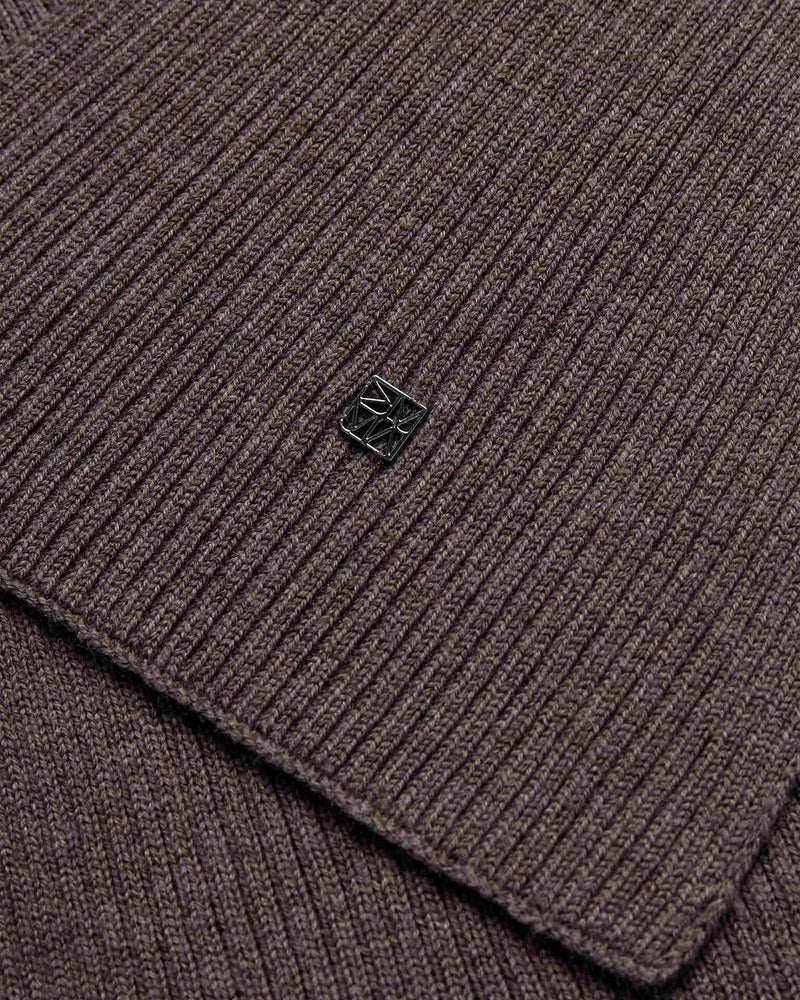 Close-up of the mole brown ribbed wool knit Mos Mosh Scarf with a small logo charm in the centre