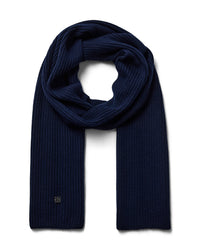 A dark navy blue ribbed Mos Mosh wool knit scarf, neatly folded and looped to display its texture and length, with a discreet logo on one end available at The Shoe Gallery