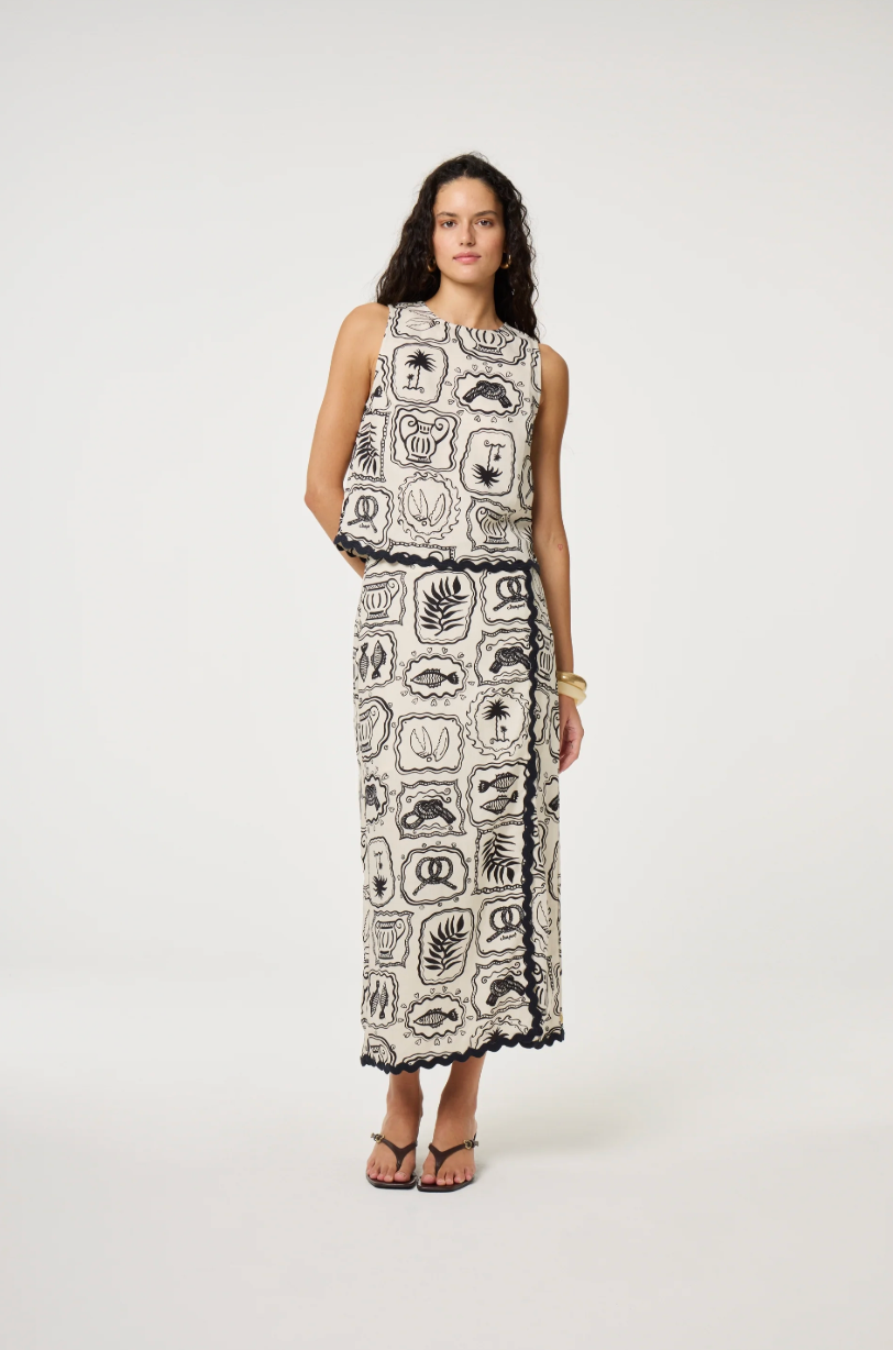 Models wears a wrap style skirt in black and white tile pattern edged with black rick rack by Fabienne Chapot