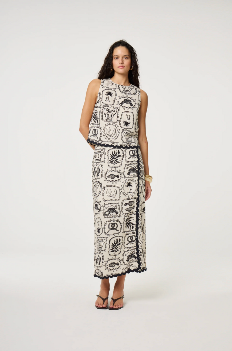 Models wears a wrap style skirt in black and white tile pattern edged with black rick rack by Fabienne Chapot