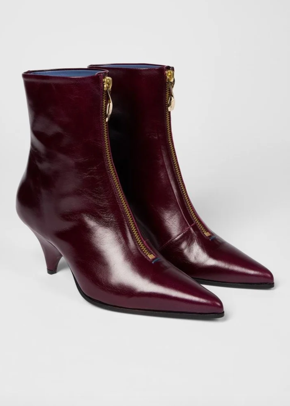 A pair of Paul Smith Winnie pointed-toe ankle boots in glossy burgundy leather with gold-tone side zippers and kitten heels, available at The Shoe Gallery