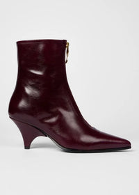 A side profile of Paul Smith Winnie pointed-toe ankle boots in glossy burgundy leather with gold-tone side zippers and kitten heels, available at The Shoe Gallery
