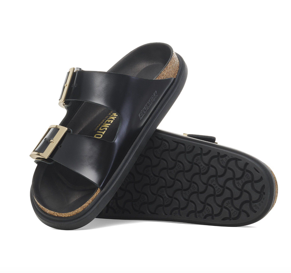 Black Birkenstock Arizona sandals with gold buckles and black bumper style soles