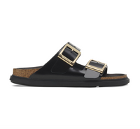 Black Birkenstock Arizona sandals with gold buckles and black bumper style soles