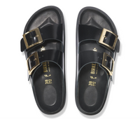 Black Birkenstock Arizona sandals with gold buckles and black bumper style soles, overhead view