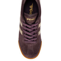 A  Gola Harrier low-top trainer in dark brown  plumb suede with gold side stripes, tonal laces, and a textured gum sole, available at The SHOE GALLERY