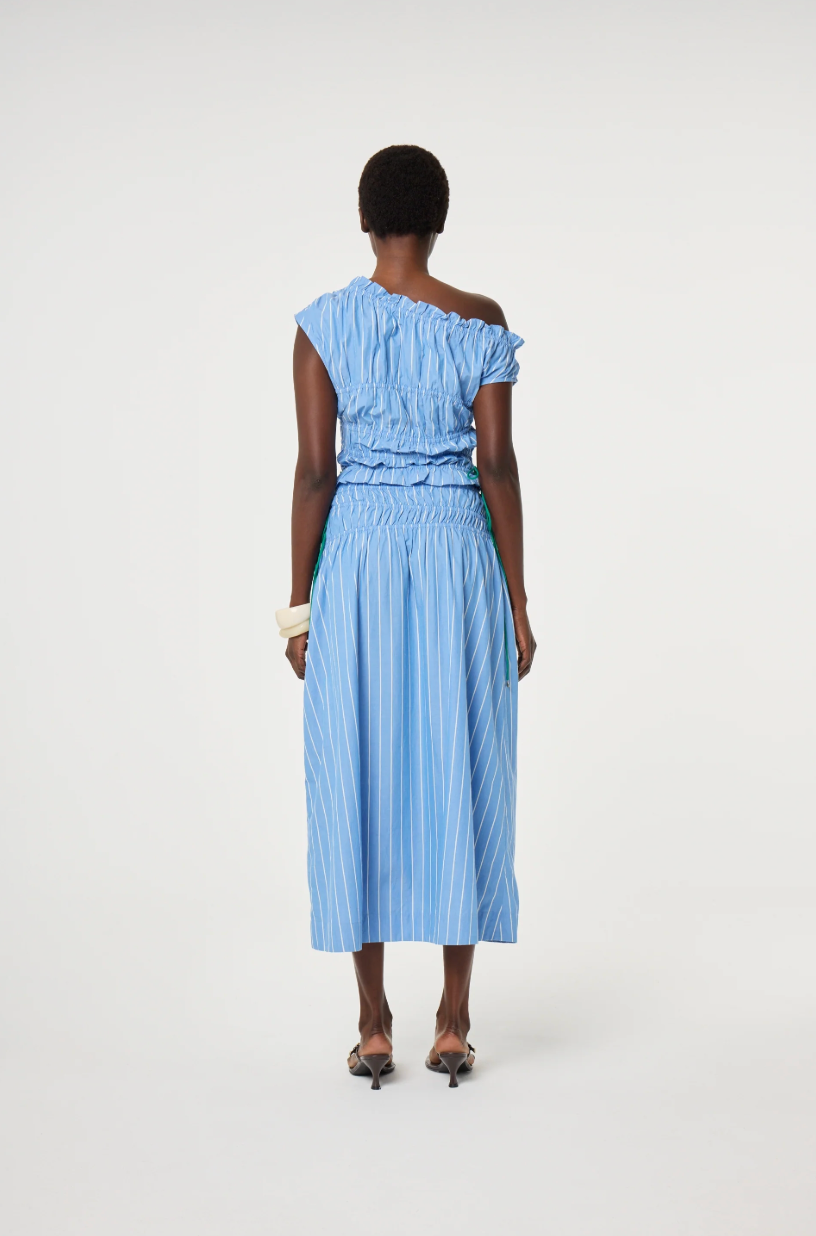 model is wearing a blue off-shoulder ruched top with green ties at the side. It is teamed with a matching Fabienne Chapot skirt, back view