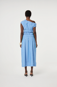 model is wearing a blue off-shoulder ruched top with green ties at the side. It is teamed with a matching Fabienne Chapot skirt, back view