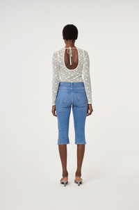 Model wearing a patterned long-sleeve cream lacey Fabienne Chapot top, back view