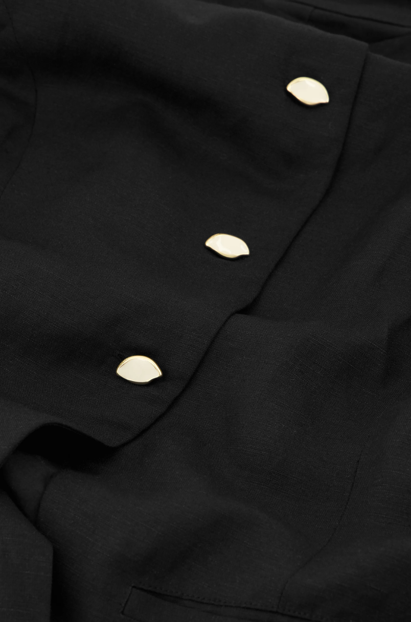 close up of black round necked Fabienne Chapot waistcoat with small cream buttons