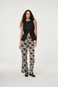 models wears a black round necked Fabienne Chapot waistcoat with small cream buttons