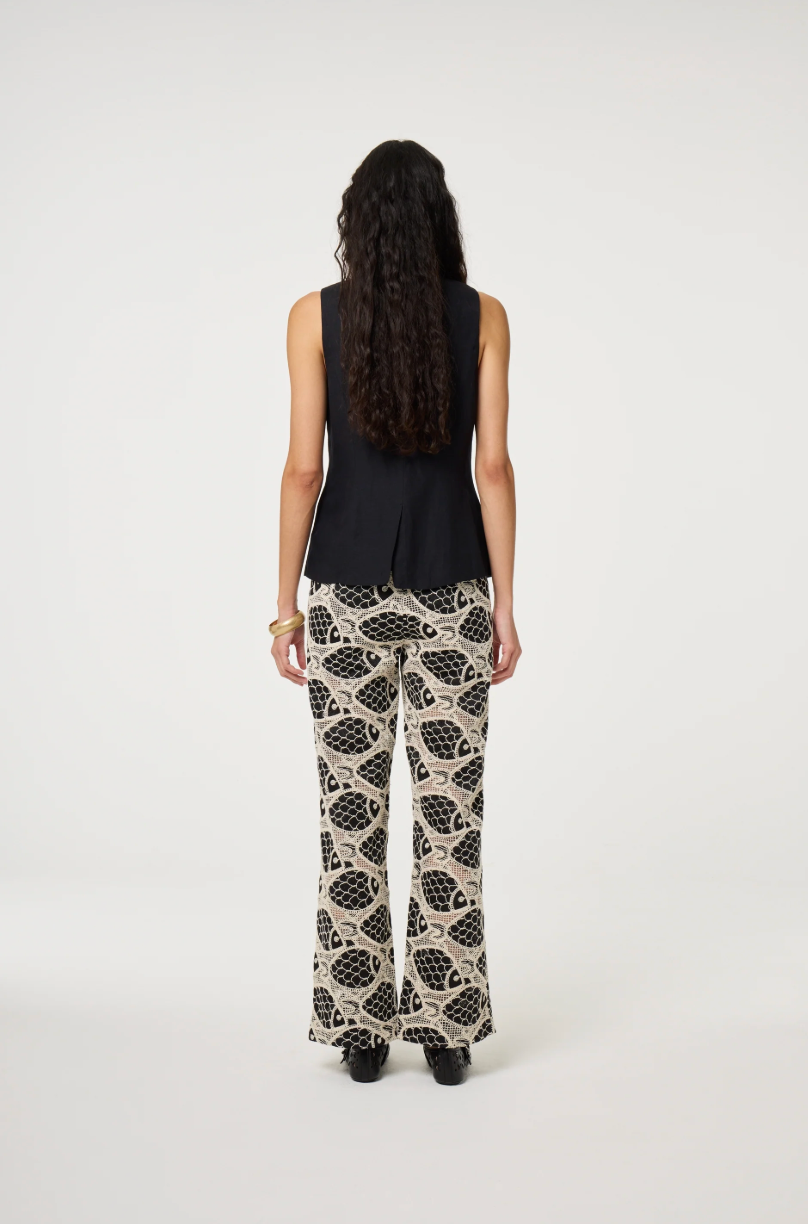 models wears a black round necked Fabienne Chapot waistcoat with small cream buttons, back view