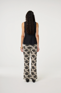 models wears a black round necked Fabienne Chapot waistcoat with small cream buttons, back view
