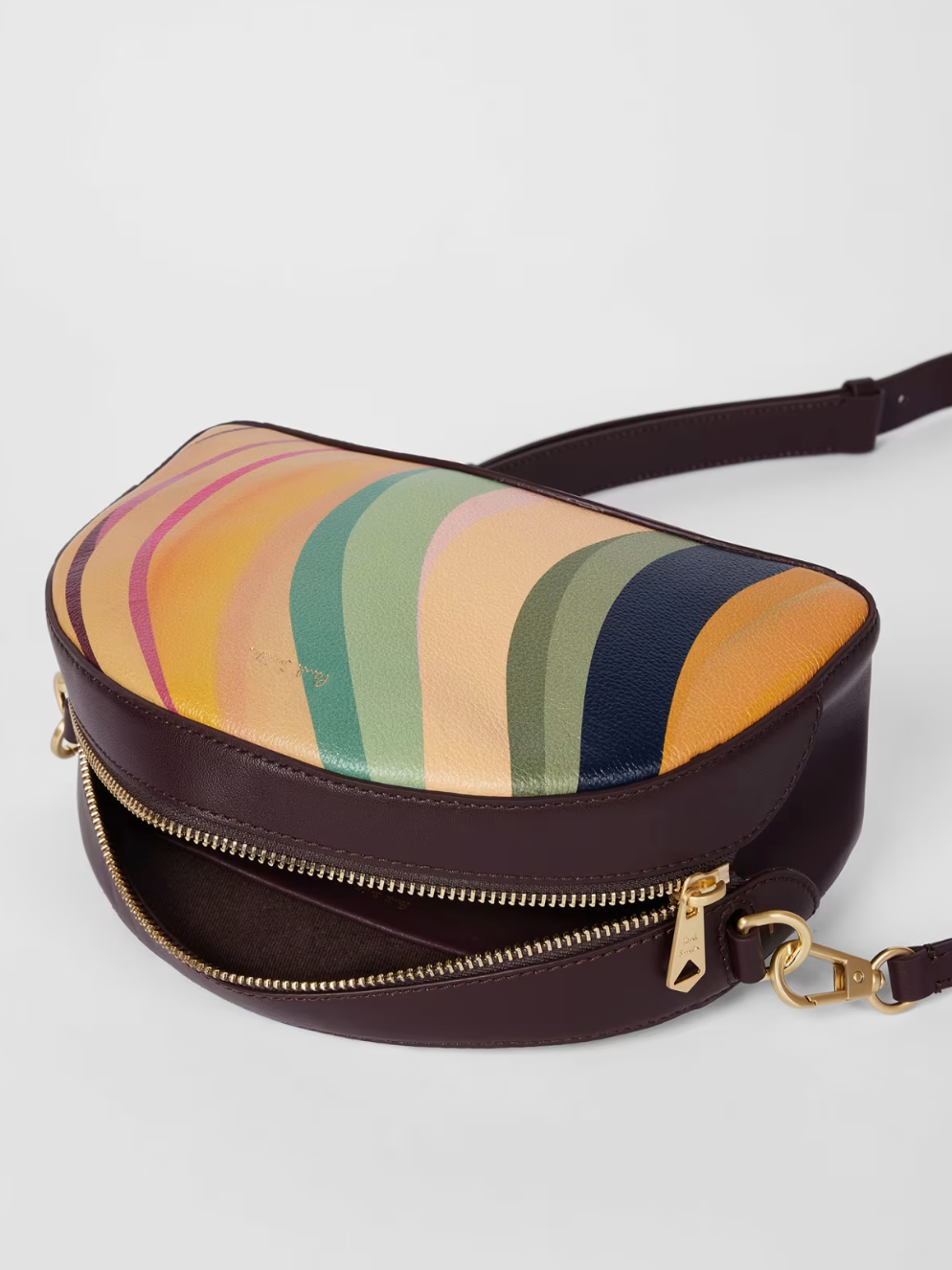 A Paul Smith dusky swirl  striped bag in a camera bag style. Centre gold coloured zip and deep burgundy across body strap, available at The Shoe  Gallery