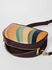 A Paul Smith dusky swirl  striped bag in a camera bag style. Centre gold coloured zip and deep burgundy across body strap, available at The Shoe  Gallery