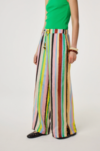 Model is wearing a green top and colorful Fabienne Chapot striped pants, side view